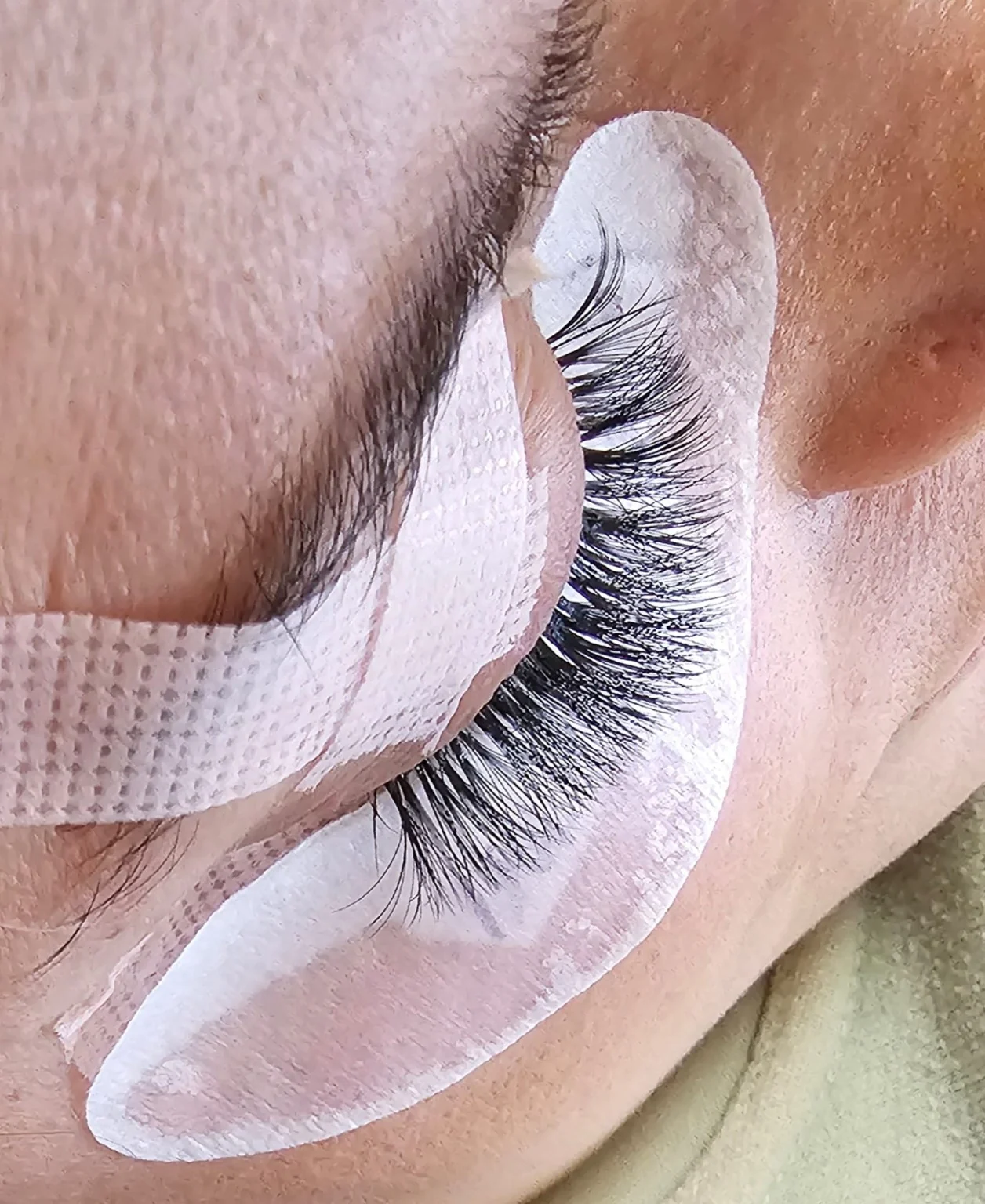 Close-up of real ALINAB lash extension application in progress